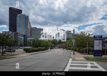 Skyline von Pittsburgh, Pennsylvania, über eine gekrümmte Parkstraße, die unter einem bewölkten Himmel zu den modernen Türmen der Innenstadt führt. Stockfoto