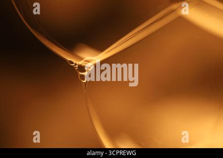 Gelbe flüssige Oberfläche, phänomenale Struktur, grüne Öle auf dunklem Hintergrund, farbenfrohe abstrakte, surrealistische Kunst, Lichtlinie Stockfoto