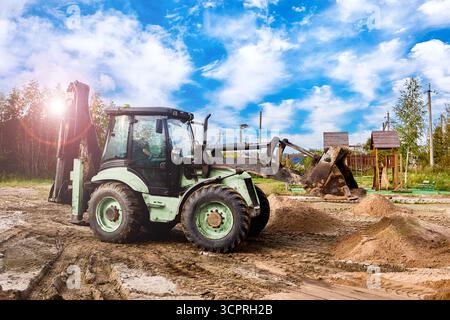 Der Frontlader befindet sich auf dem Arbeitsbereich mit Sandpfählen auf der Oberfläche, die die Phase des laufenden Bauprozesses zeigen. Stockfoto