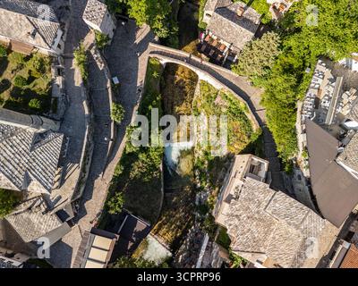 Oben nach unten Drohnenfoto der Crooked Bridge mit dem Radobolja-Fluss darunter und der Straße, die in Richtung Nezir-Agina-Moschee in Mostar führt Stockfoto