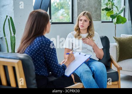 Traurige junge Patientin in Therapiesitzung mit Psychologin Stockfoto