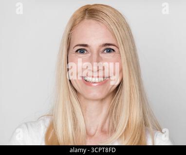Kopfschuss einer glücklichen Frau mittleren Alters mit perfekter weicher Haut Stockfoto