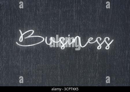 Eine Tafel mit einer handgeschriebenen Kreidebotschaft mit der Aufschrift „Business“, ein starkes Symbol für Geschäftserfolg und Motivation in Bildung und Produktion Stockfoto
