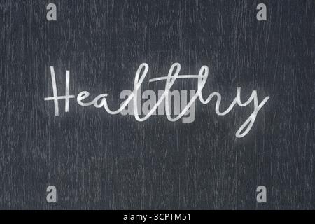Eine Tafel mit einer handgeschriebenen Kreidebotschaft, die „gesund“ sagt, ein starkes Symbol für Geschäftserfolg und Motivation in Bildung und Produktion Stockfoto