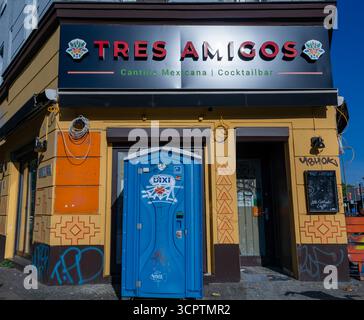 Ein mexikanisches Restaurant in Berlin Kreuzberg mit Graffiti-überdachter tragbarer Toilette direkt vor dem Eingang Stockfoto