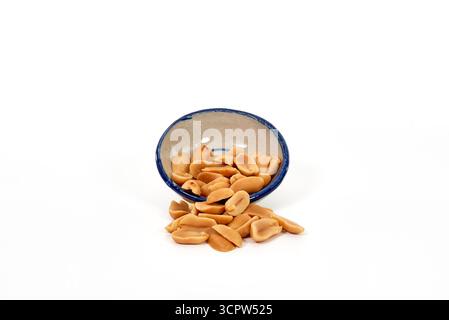 Eine kleine Keramikschale mit gerösteten und gesalzenen Erdnüssen. Ein Konzept für einen herzhaften Snack, eine Vorspeise, Partyessen oder eine Proteinquelle. Stockfoto