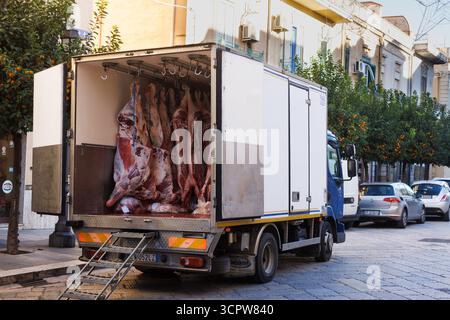 Bagheria, Italien - 17. Dezember 2024: Fleischfabrik mit Schweinefleisch und Rindfleisch, die in einem Kühlwagen an Haken hängen. Metzgerei, Kühllager für mich Stockfoto