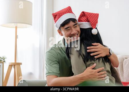 Die Weihnachtszeit im Winter bringt ein glückliches, liebevolles Paar zusammen, das pure Liebe und warme Umarmungen teilt Stockfoto