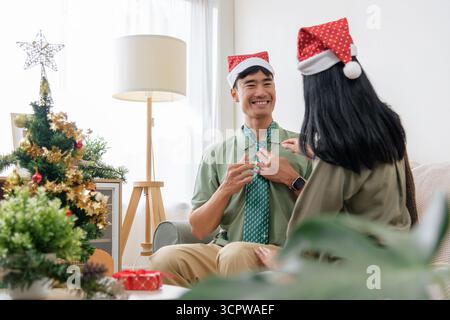 Weihnachten Happy Pärchen zeigt, dass sie zu Hause die Winterfeier lieben und festliche Freude teilen Stockfoto