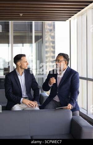 Zwei Geschäftsmänner in formellen Anzügen, die ernsthafte Gespräche führen Stockfoto