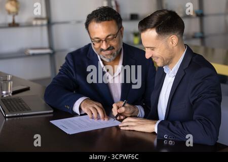 Zwei multiethnische Geschäftsleute schließen das formelle Treffen mit Vertragsunterzeichnung ab Stockfoto