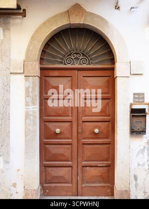 Alte braune Tür im Zentrum von Taormina, Italien. Strukturierte Tür. Vintage-Tür Stockfoto
