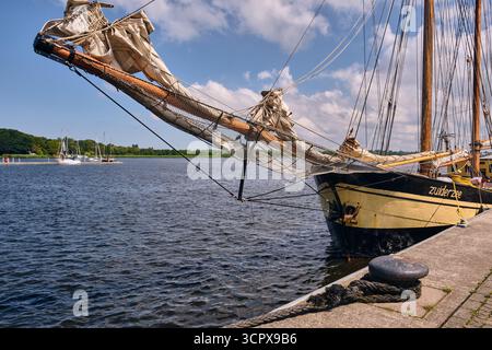 Rostock, Deutschland; 18. Juli 2025: Nahaufnahme des Bugspriets und der Takelage des niederländischen Schoners Zuiderzee mit Rollsegeln und Ankerdetails während des Festmachens Stockfoto