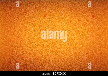 Orangefarbener Schwamm aus Mikrofasermaterial. Textur, Hintergrund Stockfoto