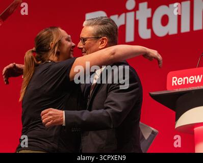 September 2025. Keir umarmt Charlotte Hennessy, deren Vater James zu den 97 Toten der Hillsborough-Tragödie gehörte. Als sie auf die Bühne kam, um zu sprechen. Premierminister Sir Keir Starmer spricht zum ersten Konferenztag der Labour-Konferenz in Liverpool. Keir Starmer saß neben dem stellvertretenden Vorsitzenden David Lammy, der zusammen mit den Kabinettsmitgliedern im Publikum applaudierte und Keir umarmte Charlotte willkommen hieß, als sie auf die Bühne kam, um zu sprechen. Liverpool UK Bild: Garyrobertsphotography Credit: GaryRobertsphotography/Alamy Live News Stockfoto