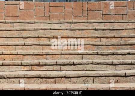 Nahaufnahme einer Steintreppe im Freien mit gemauerter Mauer. Die Treppen sind veraltet, mit sichtbarem Verschleiß und Verfärbungen auf jeder Stufe. Stockfoto