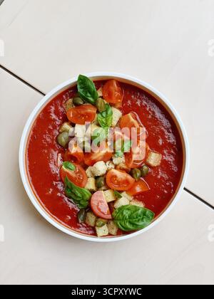 Dicke, hausgemachte Tomatensuppe. Die leuchtenden Farben und die gesunden Toppings lassen einen rustikalen und doch Gourmet-Ansatz für ein klassisches Gericht, knusprige Croutons, vermuten Stockfoto