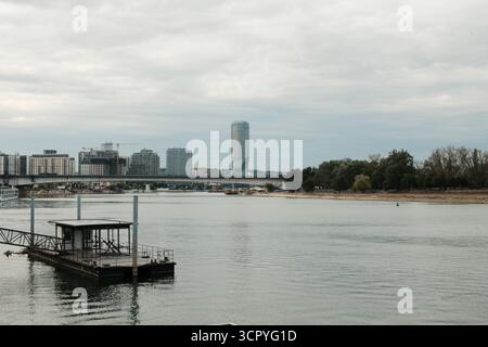 Moderne Skyline am Wasser mit hohem Turm und Brücke über den Fluss Save. Belgrad, Serbien - 28. September 2025. Stockfoto