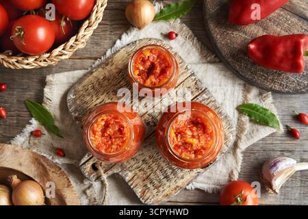 Drei Gläser gefüllt mit hausgemachten Tomaten und süßem Pfeffer (Gemüseaufstrich nach ajvar-Art, Chutney- oder Bruschetta-Topping) Stockfoto