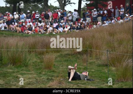 Farmingdale, USA. September 2025. Am zweiten Tag des Ryder Cup 2025 auf dem Bethpage Black Course, Farmingdale, NY, 27. September 2025, ruht ein Golffan barfuß unter dem 14. Fairway. (Foto: Anthony Behar/SipaUSA) Credit: SIPA USA/Alamy Live News Stockfoto