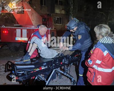 Kiew, Ukraine. September 2025. Ukrainische Strafverfolgungsbeamte unterstützen eine verwundete Person am Ort eines Luftangriffs in der Region Kiew am 28. September 2025, während der russischen Invasion in die Ukraine. Fast 500 Kampfdrohnen und mehr als 40 Raketen wurden gestartet, wobei die Hauptziele Kiew und die umliegende Region sowie Zaporischhia, Chmelnyzkyi, Sumy, Mykolajew, Tschernihiw, und Odesa. Foto vom ukrainischen staatlichen Notdienst/UPI. Quelle: UPI/Alamy Live News Stockfoto