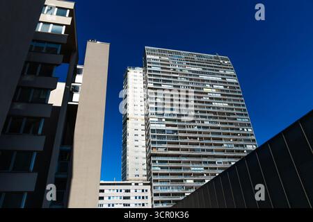 Hochhäuser mit geometrischen Formen und modernistischer Architektur unter tiefblauem, klarem Himmel Stockfoto