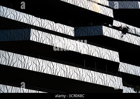 Moderne Wohnbalkone mit abstrakten geometrischen Geländermustern und dynamischen Licht-Schatten-Kontrasten in der Architektur Stockfoto
