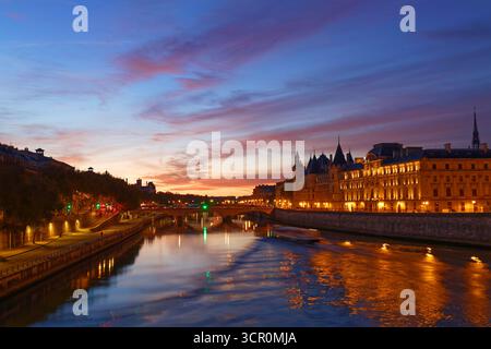 Conciergerie Gebäude entlang des Flusses Seine entfernt und das Zentrum von Paris unter einer frühen Sonnenaufgang leuchtet. Es wurde sukzessive King's Palace die Pri Stockfoto