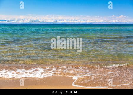 Panoramablick auf den Issyk-Kul-See mit klarem Wasser und blauem Himmel mit Wolken in Kirgisistan. Naturlandschaft von Issyk-Kul in Kirgisische Republik mit Tien-S Stockfoto