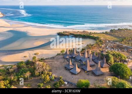 Blick auf das Dorf Ratenggaro aus der Vogelperspektive mit den traditionellen Häusern und der wunderschönen Küste während des Sonnenuntergangs am westlichen Ort der Insel Sumba, Stockfoto
