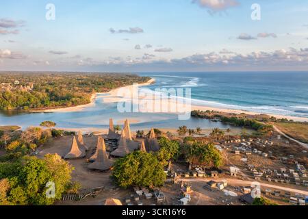 Blick auf das Dorf Ratenggaro aus der Vogelperspektive mit den traditionellen Häusern und der wunderschönen Küste während des Sonnenuntergangs am westlichen Ort der Insel Sumba, Stockfoto