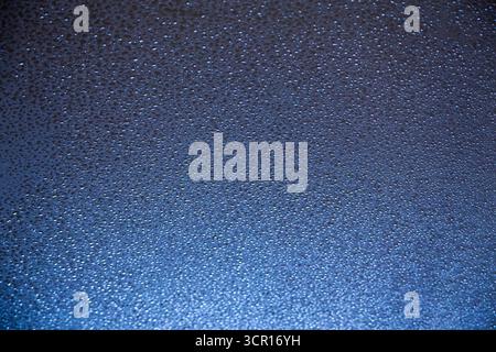 Wassertropfen auf eine blaue Oberfläche mit selektivem Fokus. Stockfoto
