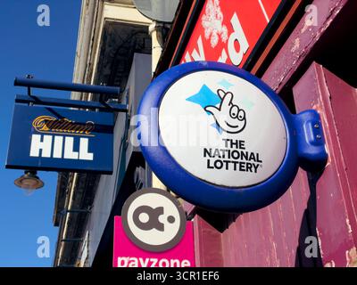 Das National Lottery-Schild vor einem 24-Stunden-Geschäft, das Lotteriescheine verkauft, Großbritannien Stockfoto