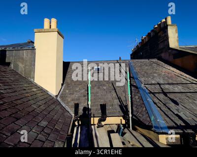 Das kommunale Dach repariert derzeit ein Gebäude in Edinburgh, installiert eine atmungsaktive wasserdichte Membranunterlage und erneuert die Sättigungsarbeiten Stockfoto