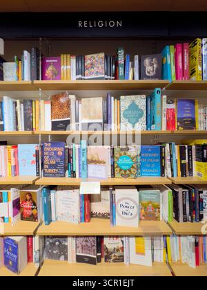 Regale mit Büchern über Religion zum Verkauf in der Buchhandlung Stockfoto