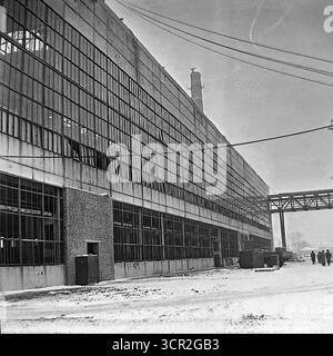 Die monumentale Fassade einer massiven neuen Fabrikwerkstatt während der Bauphase zeigt die immense Größe des Gebäudes mit seinen riesigen Wänden aus Glas und Stahlbetonplatten, um 1985. Dieses eindrucksvolle Schwarzweiß-Vintage-Foto, das in einem Industrieunternehmen in Sloviansk, der ukrainischen SSR, aufgenommen wurde, fängt das Wesen der spätsowjetischen Industriearchitektur und die großen Ambitionen der Entwicklungspläne dieser Epoche ein und ist ein Zeugnis für die großen kreativen Projekte der friedlichen Donbass-Region vor dem Krieg Stockfoto