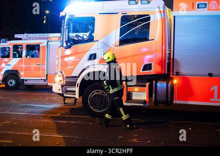 Belrlin, Deutschland. September 2025. Bei einem nächtlichen Notfalleinsatz in Berlin geht ein Feuerwehrmann an Feuerwehrfahrzeugen mit blinkenden Lichtern vorbei. Rettungsdienste, darunter Polizei, Feuerwehr und medizinisches Personal, reagierten auf einen Vorfall in der Bernauer Stra?e und Brunnenstra?e in Berlin. Im Rahmen der nächtlichen Notoperation wurde ein Medevac-Hubschrauber entsandt. (Foto: Aaron Jackendoff/SOPA Images/SIPA USA) Credit: SIPA USA/Alamy Live News Stockfoto