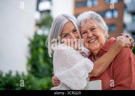 Porträt einer schönen erwachsenen Tochter mit alter Mutter. Stockfoto