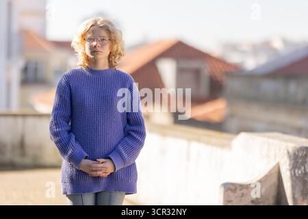 Junge Frau mit Brille auf dem Dach Stockfoto
