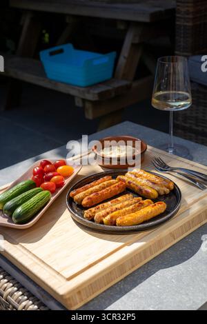 Gegrillte Würstchen mit Gewürzen auf Holzbrett Stockfoto