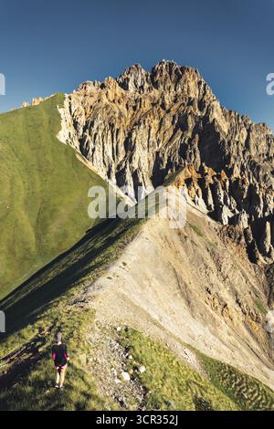 Wanderer auf schmalen Bergwanderwegen am Kabarjina Mountain im Kazbegi Nationalpark Georgia mit dramatischer Aussicht auf den felsigen Gipfel Stockfoto