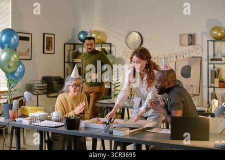 Vielfältige Gruppe von Kollegen feiert Geburtstag in moderner Büroumgebung Stockfoto