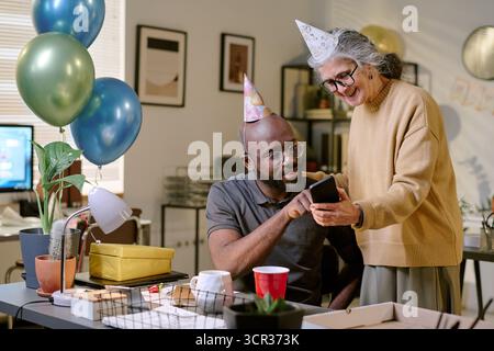 Ältere Frau und Schwarzer mittleren Alters feiern gemeinsam Geburtstag Stockfoto