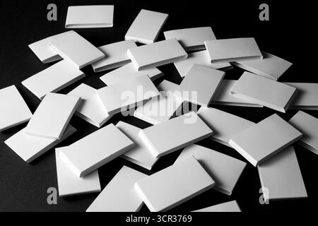 Stapel von leeren weißen rechteckigen Objekten auf schwarzer Oberfläche Stockfoto