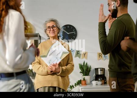 Porträt einer Seniorin mit Zertifikat während der Feier Stockfoto