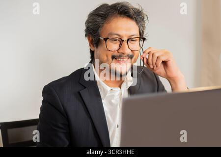 Fröhlicher Support Telefonhörer im Headset, am Arbeitsplatz bei Verwendung von Laptop, Help Service und Kundenberatung Call Center Konzept. Stockfoto