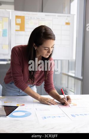 Frau, die wichtige Schlüsselpunkte auf Haftnotiz schreibt Stockfoto