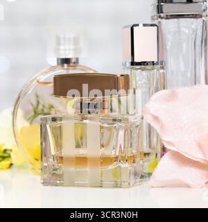 Elegante Parfümflaschen mit weichen Blumen und Stoff in einer Schönheitsausstellung Stockfoto