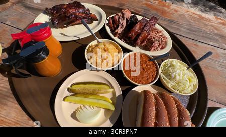 Grillkoteletts und Rippchen, perfekt gegrillt, rauchige Essensplatte, heiß mit Sauce und Beilagen serviert – ultimatives Grillfest für Fleischliebhaber und Grill Stockfoto