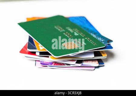 Gestapelte Sammlung verschiedener Kredit- und Treuekarten auf einer weißen Oberfläche Stockfoto